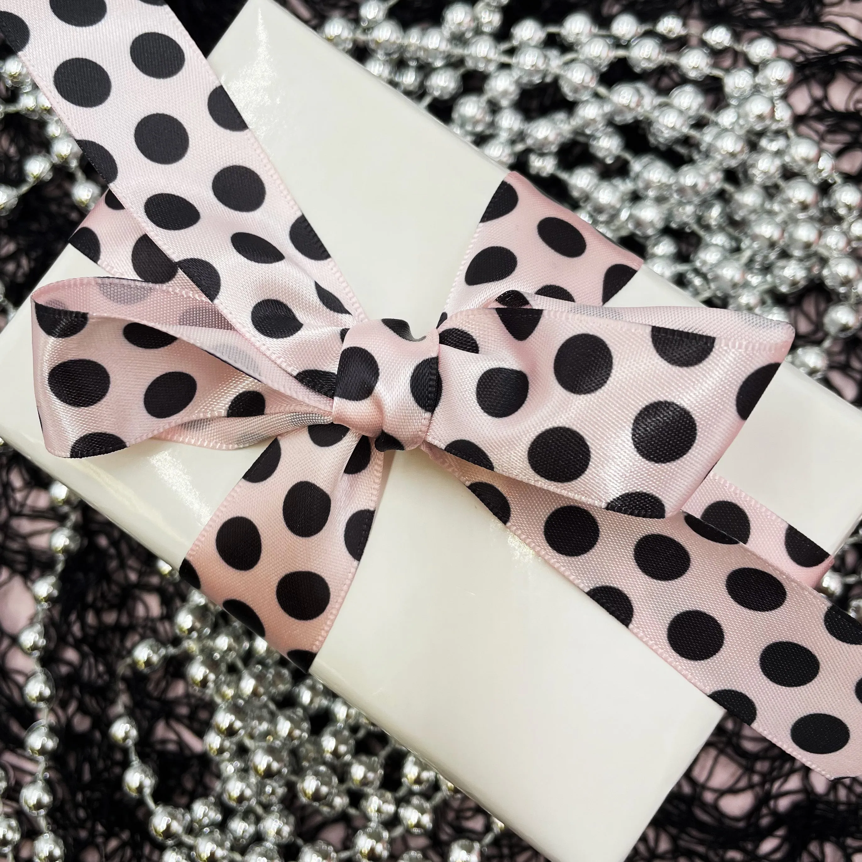 Black  dots ribbon printed on 7/8" light pink single face satin